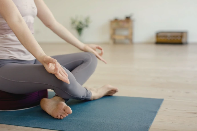 A woman in a yoga pose on a blue mat